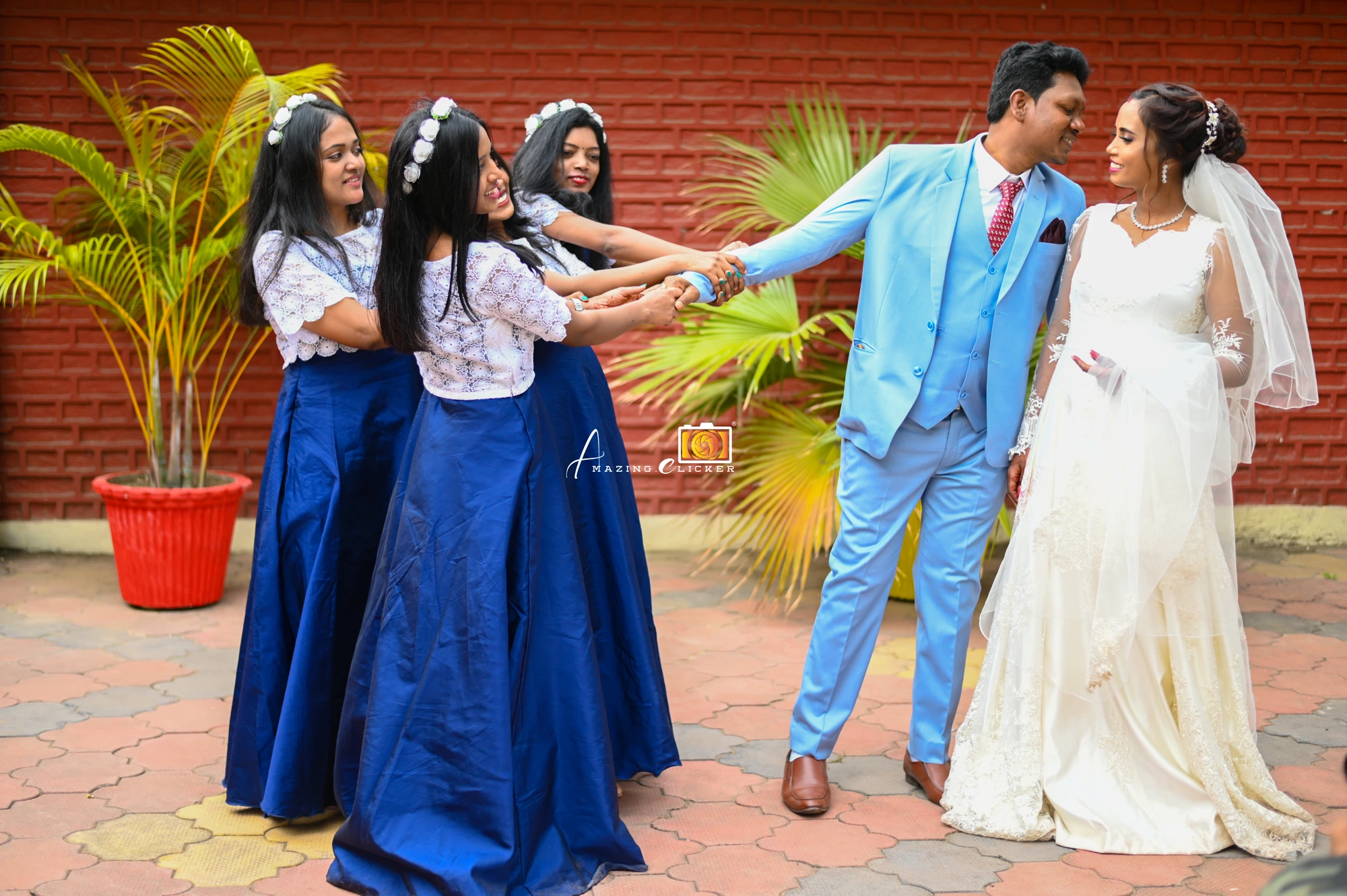 Couple celebrating with bridesmaids in blue gowns